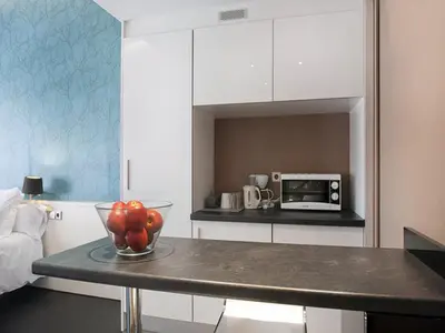 a kitchen with a bowl of apples on a table at Barcelona Fifteen central Aparthotel in Barcelona