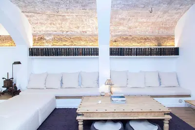 a living room with a white couch and a table at A historic XVI century beach home near Barcelona in Caldes d'Estrac