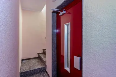 a red door in a hallway with stairs at HomeHolidaysRentals Etoile in Calella