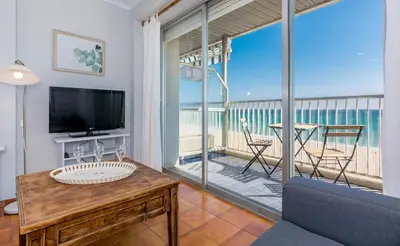 a living room with a tv and a balcony at HomeHolidaysRentals Etoile in Calella