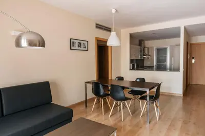 a living room with a dining room table and chairs at Barcelona Apartment Villarroel in Barcelona