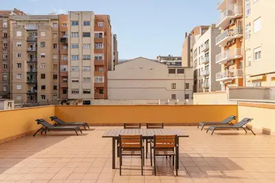 a patio with chairs and a table on a roof at Barcelona Apartment Villarroel in Barcelona