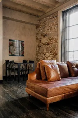 a living room with a brown couch and a table at Aparthotel Arai 4* Superior in Barcelona