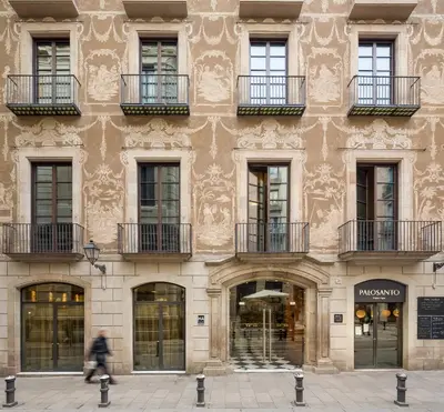 a man walks past a building with windows and balconies at Aparthotel Arai 4* Superior in Barcelona