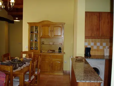 a kitchen with wooden cabinets and a table and a counter at Mansion in Maians with Private Pool in Castellfullit del Boix