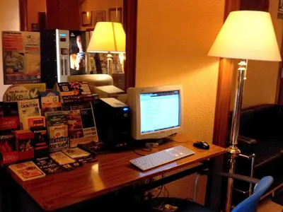 a desk with a computer monitor and a keyboard at Hotel Toledano Ramblas in Barcelona