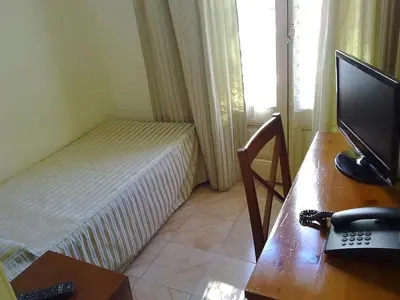 a bedroom with a bed and a desk with a computer at Hotel Toledano Ramblas in Barcelona