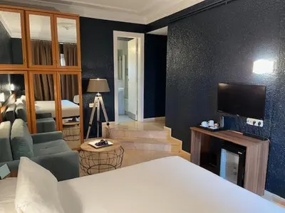 a bedroom with a bed and a couch and a chair at Hostal Iznájar Barcelona in Barcelona