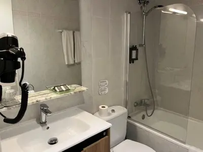 a bathroom with a shower and a toilet and a sink at Hostal Iznájar Barcelona in Barcelona