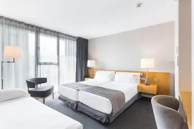 a hotel room with two beds and a window at Hotel Royal Passeig de Gracia in Barcelona