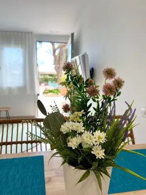 a vase filled with flowers sitting on a table at Bamblue Boutique Apartments in Pineda de Mar