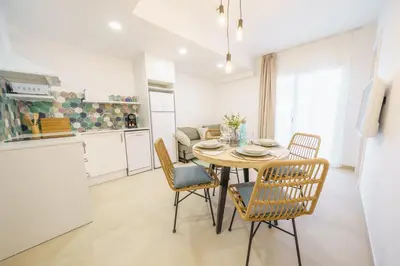 a kitchen and dining room with a table and chairs at Bamblue Boutique Apartments in Pineda de Mar