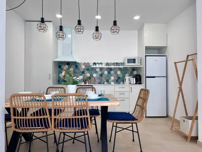 a kitchen with a dining room table and chairs at Bamblue Boutique Apartments in Pineda de Mar