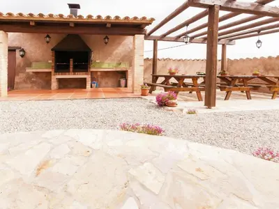 an outdoor patio with a picnic table and a grill at Cottage in Maians with Sea View & Pool in Castellfullit del Boix