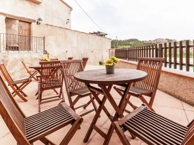 a wooden table and chairs on a patio at Cottage in Maians with Sea View & Pool in Castellfullit del Boix