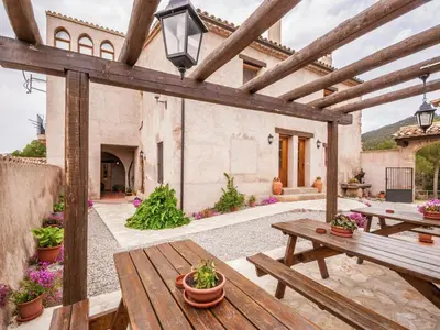 an outdoor patio with wooden tables and potted plants at 17th century farmhouse in Bages, near Montserrat in Castellfullit del Boix