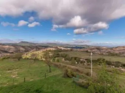 a green field with a view of the mountains at 17th century farmhouse in Bages, near Montserrat in Castellfullit del Boix