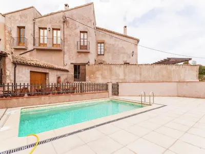a villa with a swimming pool in front of a house at 17th century farmhouse in Bages, near Montserrat in Castellfullit del Boix