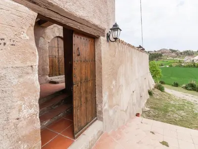 an entrance to a stone building with a wooden door at 17th century farmhouse in Bages, near Montserrat in Castellfullit del Boix