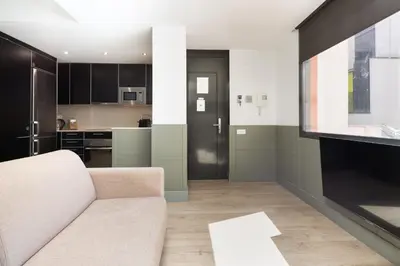 a living room with a couch and a kitchen at Enjoybcn Patio de Gala in Barcelona
