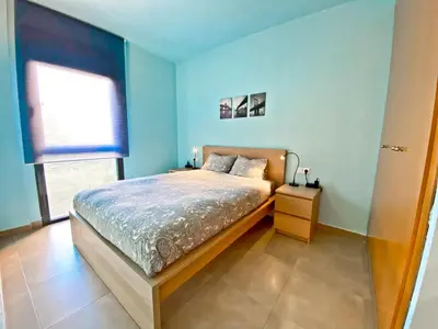a bedroom with blue walls and a bed and a window at Urban Manresa-City center apartment with balcony in Manresa