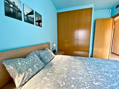a bedroom with a bed with a blue wall at Urban Manresa-City center apartment with balcony in Manresa