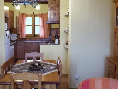 a kitchen with a wooden table and a table and chairs at Cottage in Maians with Pool and Garden in Castellfullit del Boix