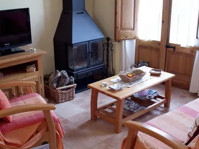 a living room with a fireplace and a coffee table at Cottage in Maians with Pool and Garden in Castellfullit del Boix