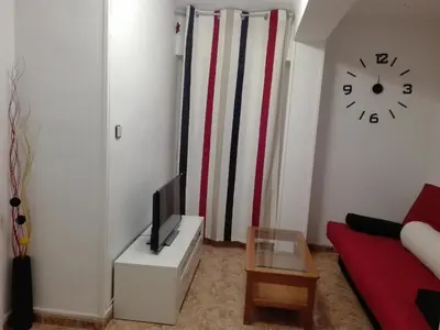 a living room with a tv and a clock on the wall at UN ESPACIO DONDE CREAR GRANDES RECUERDOS in Calella