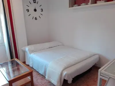 a room with a bed and a clock on the wall at UN ESPACIO DONDE CREAR GRANDES RECUERDOS in Calella
