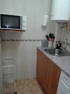 a small kitchen with a sink and a microwave at UN ESPACIO DONDE CREAR GRANDES RECUERDOS in Calella