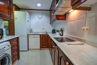 a kitchen with a sink and a refrigerator at Clarimar Apartment by Hello Homes Sitges in Sitges