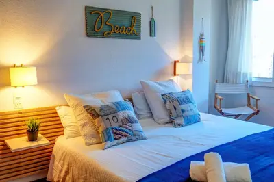 a bedroom with a bed with blue and white pillows at Clarimar Apartment by Hello Homes Sitges in Sitges
