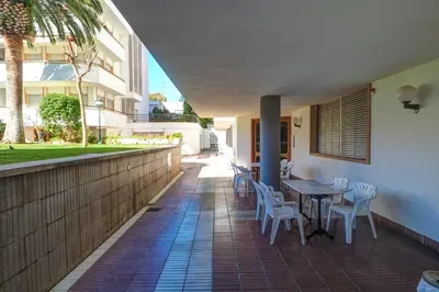 a patio with a table and chairs and a building at Clarimar Apartment by Hello Homes Sitges in Sitges