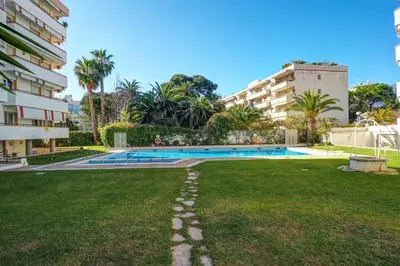 a yard with a swimming pool and a building at Clarimar Apartment by Hello Homes Sitges in Sitges
