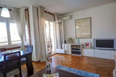 a living room with a table and a television at Clarimar Apartment by Hello Homes Sitges in Sitges