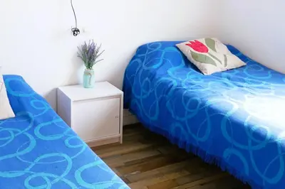 a bedroom with two beds and a night stand with a vase at Ca la Nena Morena - Refugio cálido con chimenea y vistas al Montseny in Vallgorguina