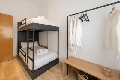 a small bedroom with a bunk bed and a bench at Petit Luxe Ègara in Terrassa