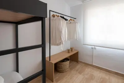 a bedroom with a closet with white clothes on hangers at Petit Luxe Ègara in Terrassa