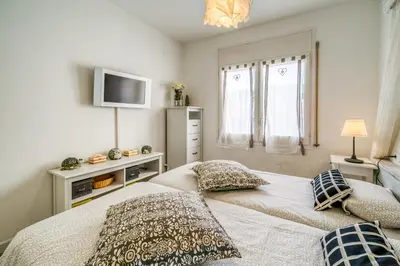 a bedroom with a bed with two pillows and a television at Vivalidays ilaria - Calella in Calella