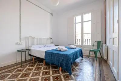 a bedroom with a bed and a table and chairs at b32-Sunny and Modernist apartment for groups in center in Barcelona