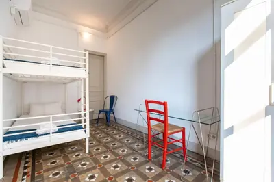 a bedroom with two bunk beds and a red chair at b21-Apartamento Modernista para Grupos in Barcelona