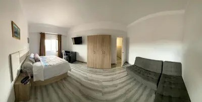 a bedroom with a bed and a couch in a room at Hostel Penedes in Vilafranca del Penedès