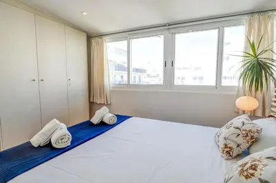 a bedroom with a large white bed with two pillows at Secret Garden Apartment by Hello Homes Sitges in Sitges