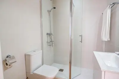 a bathroom with a shower and a toilet and a sink at Secret Garden Apartment by Hello Homes Sitges in Sitges
