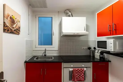 a kitchen with red cabinets and a sink at Magnifico apartamento camp nou in Barcelona