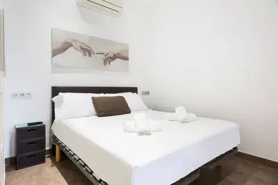 a white bed in a room with a painting on the wall at Stay U-nique Apartments Eixample Center in Barcelona
