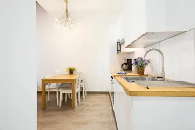 a kitchen with a sink and a table in it at Stay U-nique Apartments Eixample Center in Barcelona