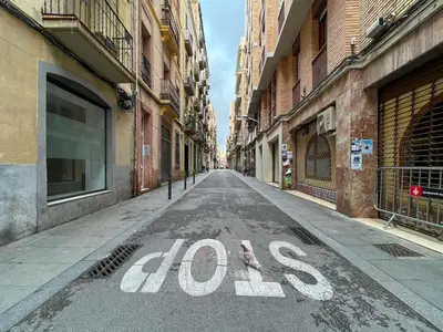 an empty street with the wordoks written on the road at Stay U-nique Apartments Torrent in Barcelona