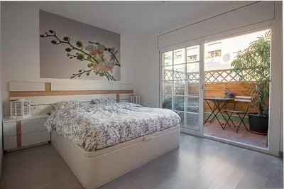 a bedroom with a large bed and a balcony at Kamelly in Badalona